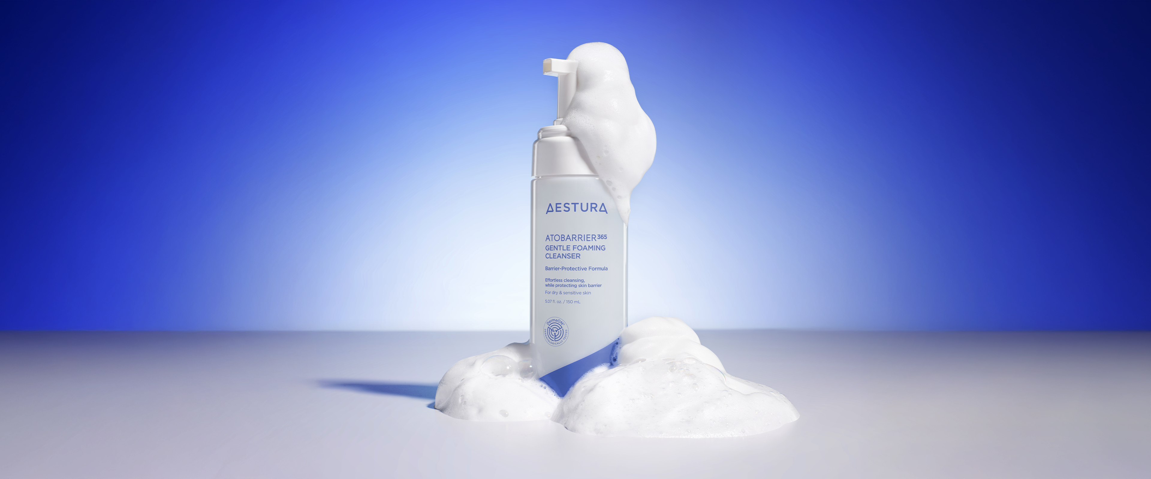 Hand holding Aestura Atobarrier365 Cream in front of a solid blue background