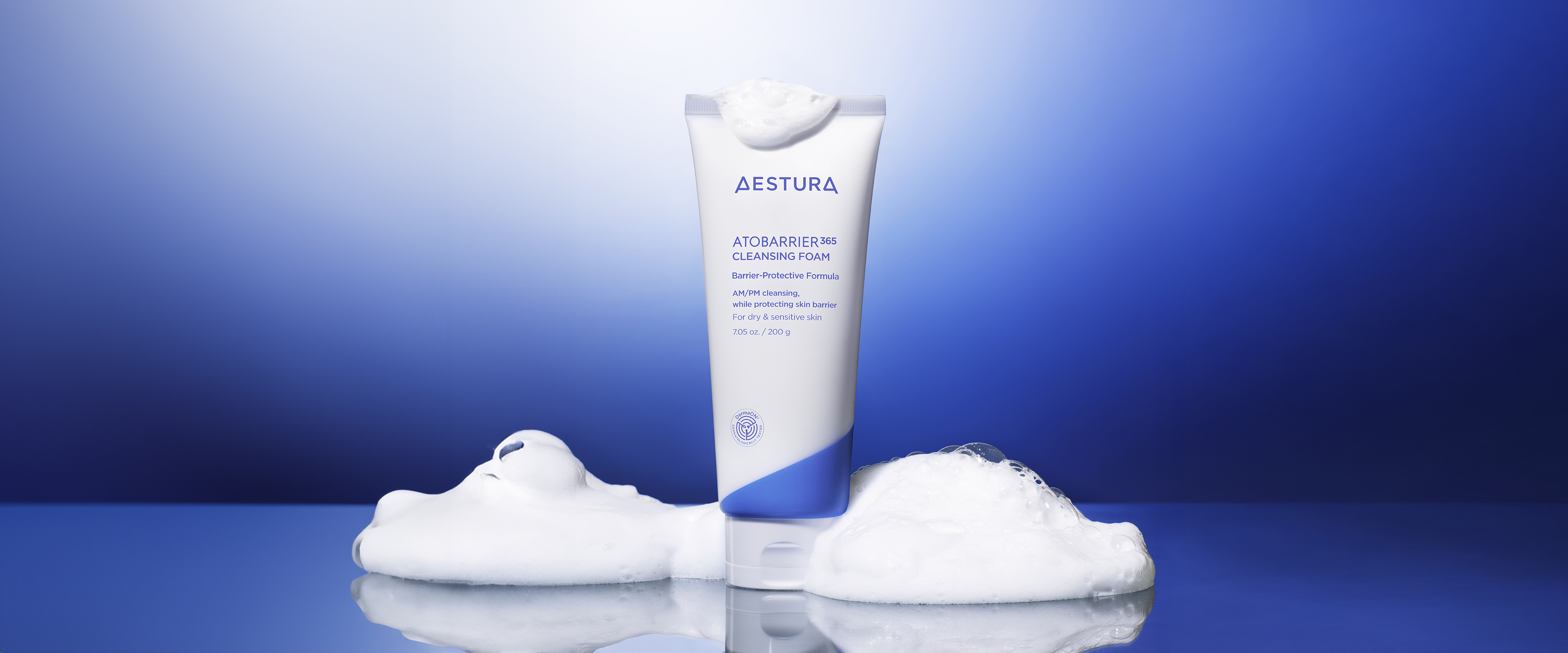 Hand holding Aestura Atobarrier365 Cream in front of a solid blue background
